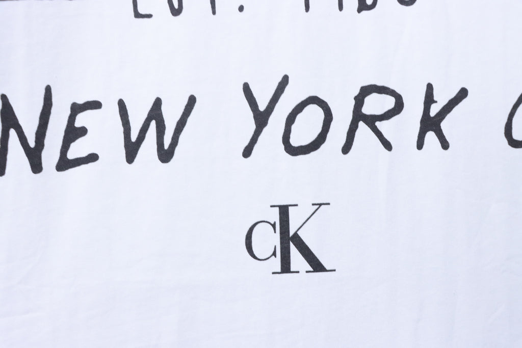 Närbild på svart texttryck och CK-logotyp