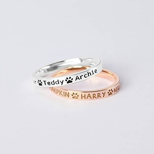 Brass rings in silver and rose gold with engraved pet names and pawprint designs. Simple, elegant, and customizable.