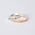 Brass rings in silver and rose gold with engraved pet names and pawprint designs. Simple, elegant, and customizable.