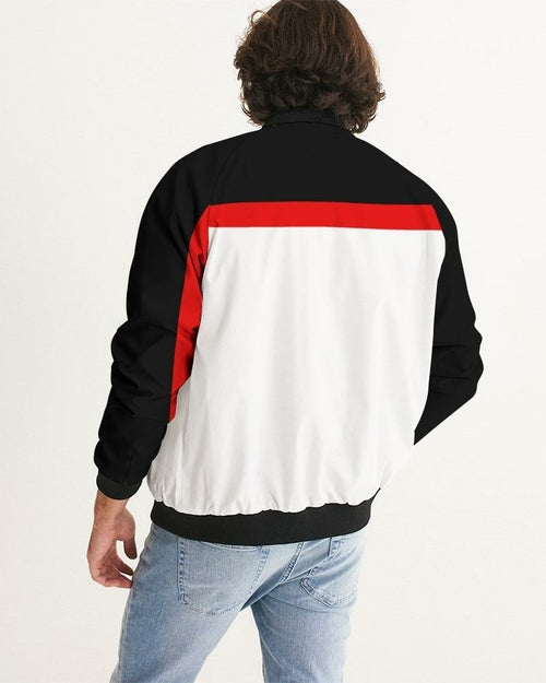 Men's bomber jacket featuring a black, white, and red color block design, ribbed hem, and cuffs, worn casually over blue jeans.