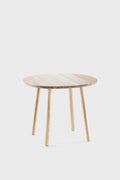 Round wooden dining table with a light oiled ash tabletop and sturdy, natural wood legs. Simple and inviting design.