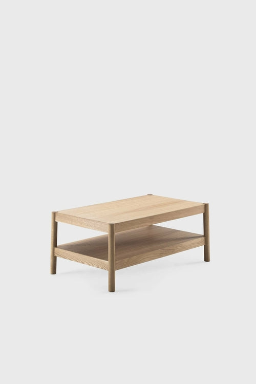 Light oak rectangular side table with a smooth surface and an open bottom shelf. Uncovered round legs highlight its structure.