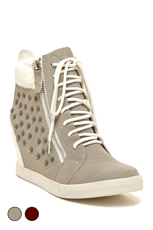 Gray wedge sneakers, featuring a side zipper, white laces, and studded detail on one side.