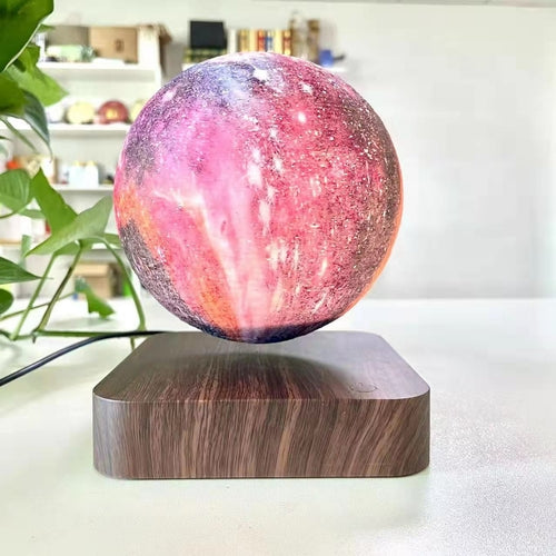 3D-printed moon lamp in vibrant pink and purple hues, levitating above a wooden base with a smooth finish.