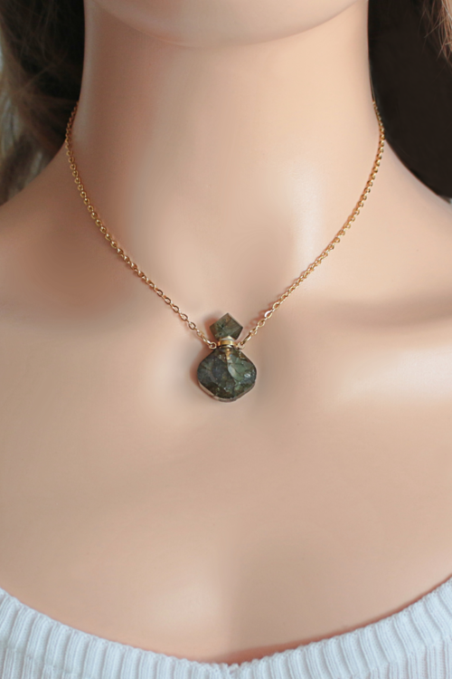 Dainty gold-plated necklace featuring a unique Labradorite crystal bottle pendant, worn close to the neck.