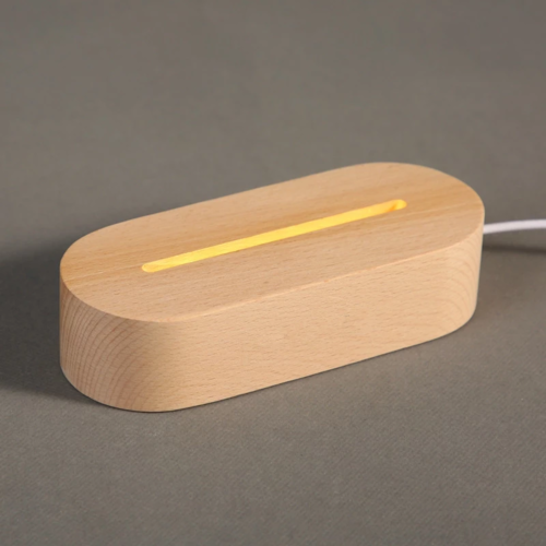 Wooden table lamp with a smooth, light wood finish and a narrow light slot, providing warm illumination.