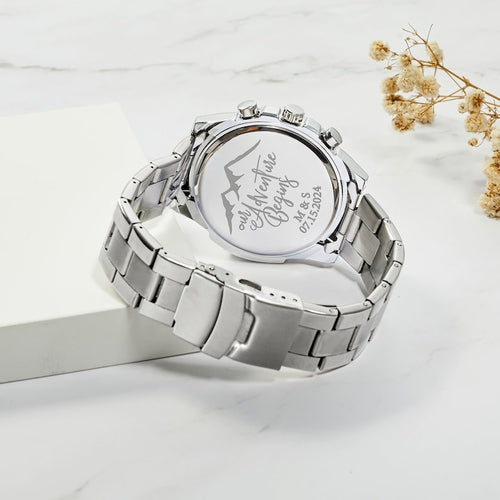 Stainless steel men's watch with a silver band, featuring an engraved mountain design and the phrase "Our Adventure.