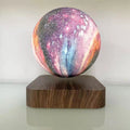Colorful 3D print moon lamp seemingly levitating above a wooden base, featuring a galaxy pattern with vibrant hues.