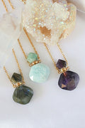 Three gold-plated necklaces featuring uniquely shaped natural crystal bottles: labradorite, amazonite, and amethyst.