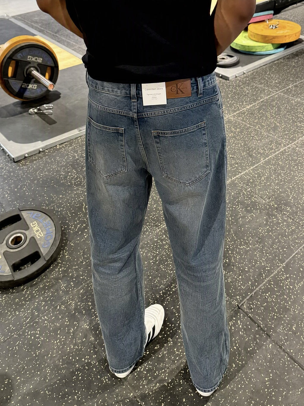 Blå jeans burna bakifrån med Calvin Klein Jeans-etikett