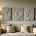 Graceful Decorative Wall Sculpture in soft beige, featuring abstract shapes, enhancing a cozy interior with textured panels.
