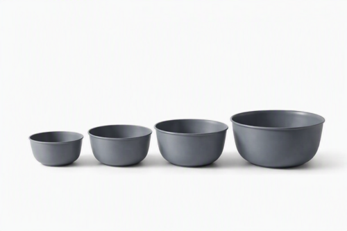 Four gray mixing bowls of varying sizes stacked, with a sleek, modern design and smooth matte finish.